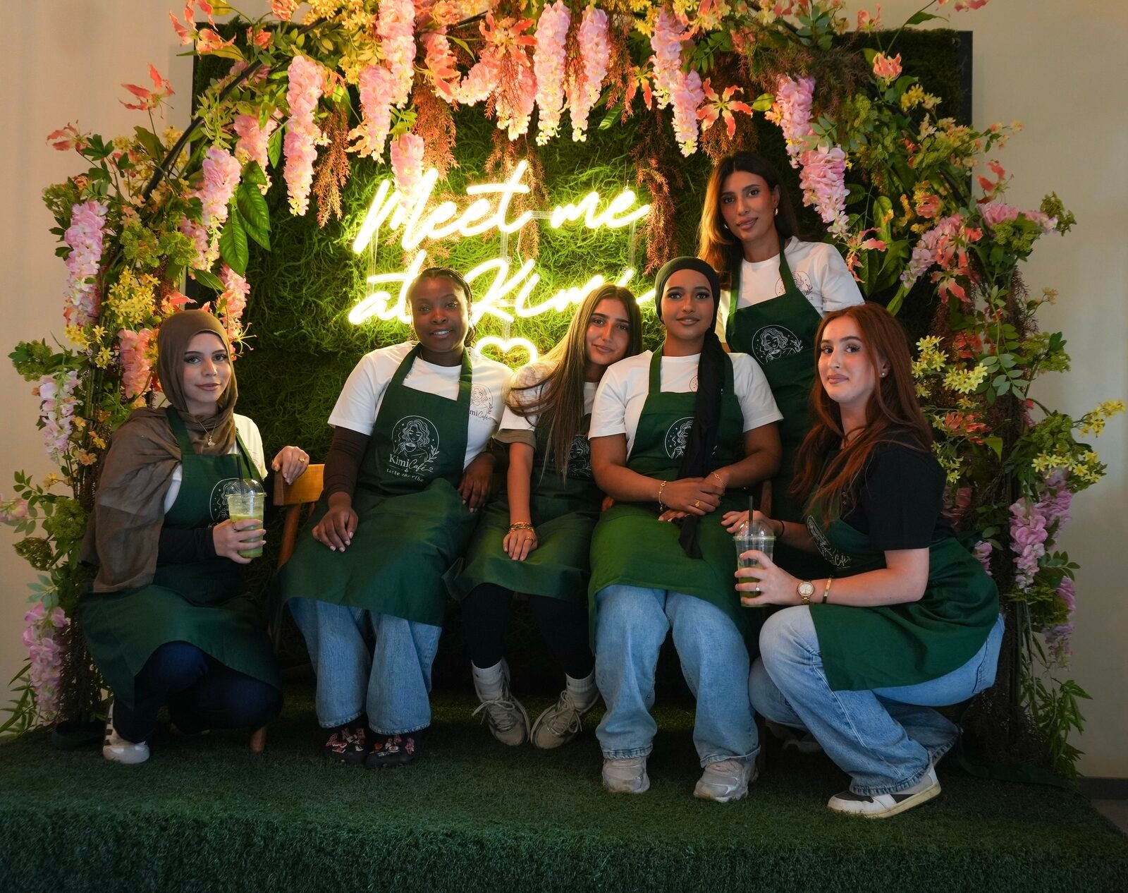 Het team van Kimi Café voor de bloemenboog op de openingsavond